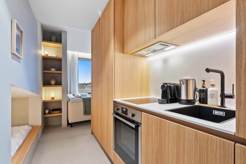 Sleek Kitchenette – Fully equipped with modern appliances, including a stovetop, coffee maker, and toaster.