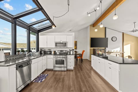 Enjoy cooking in the brightly lit fully stocked kitchen with its open living space with the living room.
