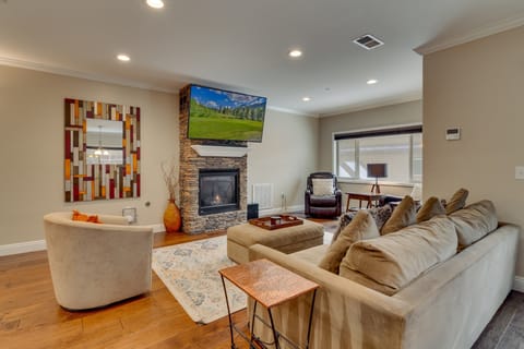 Living area with comfy couch. stone fireplace, and flat screen TV