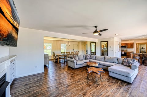 A cozy and spacious living room with a large sectional sofa, a fireplace, and expansive windows offering beautiful lake views.