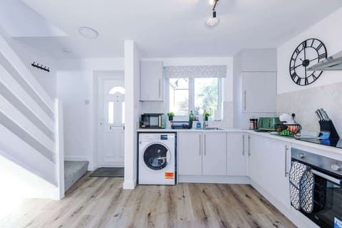 The kitchen is fully equipped with modern appliances, including a coffee machine, making it a perfect space for preparing meals and enjoying your morning brew. It offers ample counter space and storage, ideal for both cooking and casual dining.