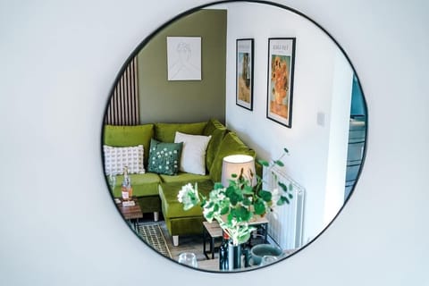 The living room features a comfortable sofa bed, a smart TV, and an open-plan dining area, perfect for relaxing and entertaining. Large doors offer easy access to the backyard, creating a seamless connection between indoor and outdoor living spaces.