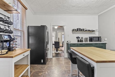 Modern full kitchen featuring a spacious long table, refrigerator, microwave, and essentials, with drawers underneath for storage, neatly arranged cups, and a functional layout—perfectly designed for convenience and style