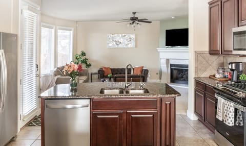 Island in the kitchen features a dishwasher and overlooks the living room