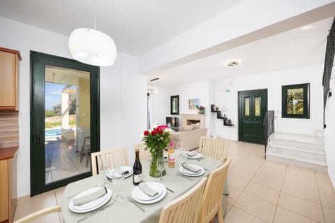 Open-plan living room with sofas, dining area, kitchen, ornamental fireplace, A/C, WiFi internet, satellite TV, and sea views