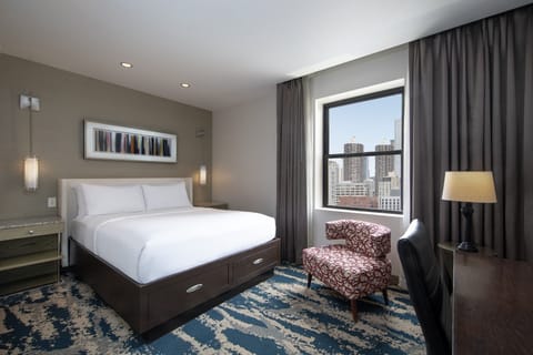 Wake up to city views from a serene, sunlit bedroom.