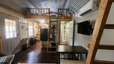 Main living/bedroom area with queen bed loft room above the kitchen.