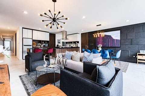 Inviting and spacious living room with unique light fixtures and cozy seating, perfect for entertaining.