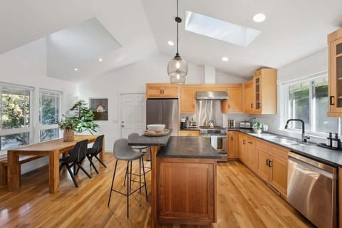 Enjoy cooking and dining in this sun-filled kitchen with natural wood finishes and open, airy design.