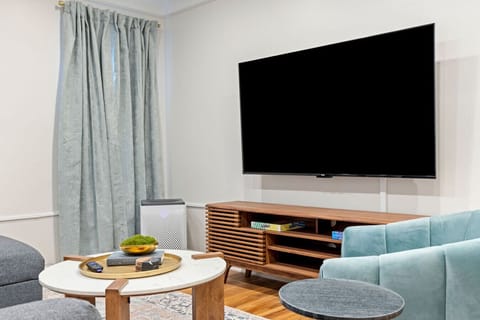 Modern and inviting living room corner with a TV, stylish wooden console, and cozy seating—perfect for entertainment and relaxation.