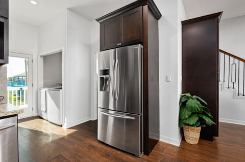 The refrigerator conveniently located near the pathway to the laundry area, providing easy access to both essentials while maximizing space and efficiency