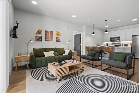 The open living area is filled with natural light and boasts chic furnishings, creating an inviting atmosphere for both relaxation and entertainment.