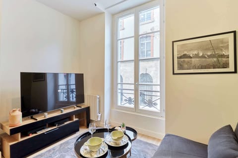 Pièce principale avec canapé lit, TV et cuisine