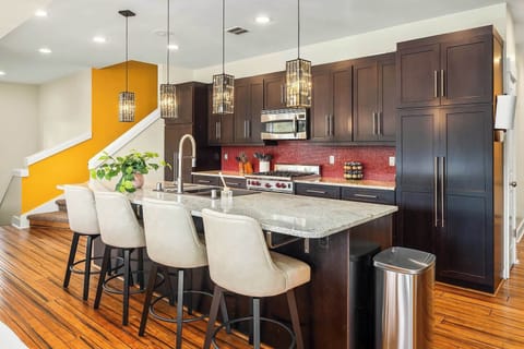 The side view of the kitchen highlights a stylish countertop with seating for four, seamlessly integrated into the sleek design. The layout showcases modern cabinetry, high-end appliances, and a functional workspace, offering a perfect balance of con