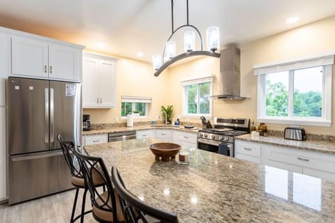 Enjoy cooking in this stylish, modern kitchen with a spacious granite island, stainless steel appliances, and plenty of natural light. Perfect for gathering with friends or family, this space combines elegance and functionality to enhance your stay.