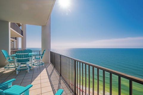 This spacious balcony features bright turquoise seating with stunning beachfront views from the thirty-first floor