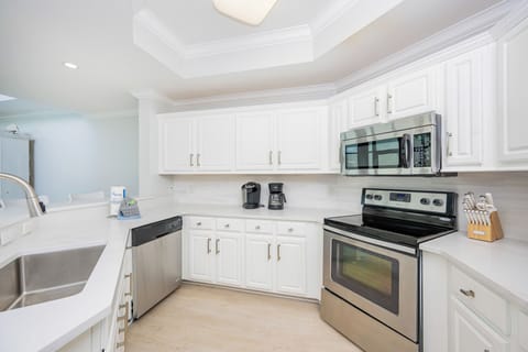 This kitchen features white cabinetry, stainless appliances, a Keurig and a coffee maker for a delightful cooking experience