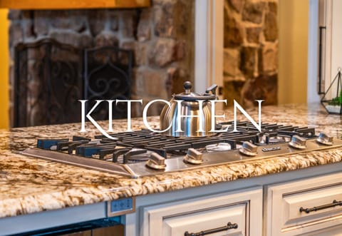 A sleek, modern stovetop takes center stage in the kitchen, perfectly positioned for preparing meals while staying connected with friends and family in the open layout.