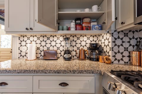 Coffee station: mugs, drip coffee machine, coffee, creamers, sugar, & tea