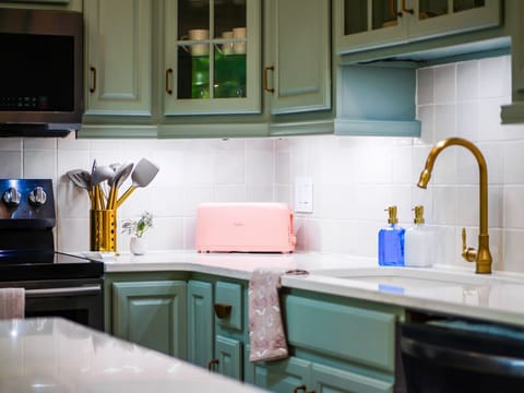 Details that delight 🍞💫 From the soft teal cabinets to the pink retro toaster and brushed gold fixtures, this kitchen is a stylish blend of cozy and chic—fully stocked for all your culinary adventures.