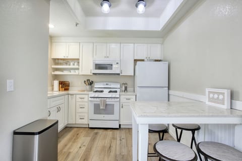 Fully equipped kitchen with everything you need to cook and serve, plus dining for four — perfect for sharing meals after a day at the beach.