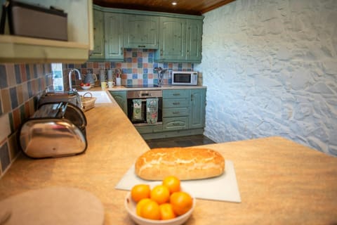 Kitchen with marble effect worktop with a loaf of bread and bowl of fruit on