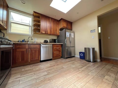 Kitchen features a stove/oven, large sink, refrigerator, and other appliances.