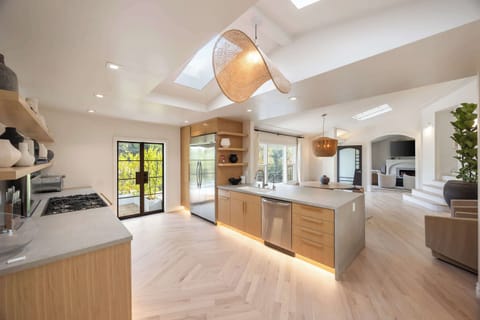 Expansive kitchen featuring a central island, high-end appliances, and skylit elegance.