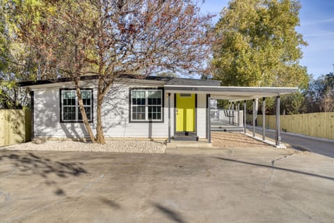 Charming Exterior: Bright yellow door welcomes you to your Austin retreat, surrounded by lush greenery!