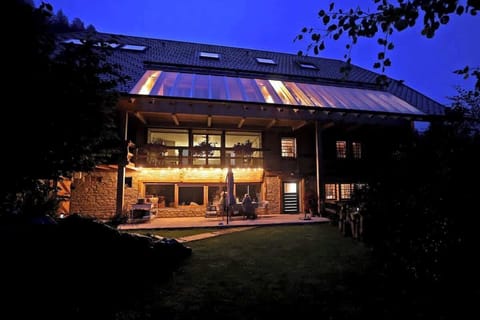 Die Außenansicht des Haldehof Loft bei Nacht verzaubert mit sanftem Licht, das die elegante Architektur betont und eine einladende, warme Atmosphäre schafft – der perfekte Ort für unvergessliche Abende im Schwarzwald.