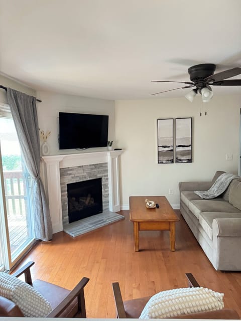 Living Room w/ Couch, Two Oversized Faux Leather Chairs, and a 50-inch Smart TV with Roku.