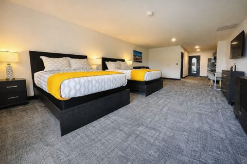 Cozy bedroom featuring a comfortable beds and a sofa with vibrant throw pillows, ideal for relaxing after a day of exploring.