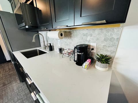 Coffee station with a variety of supplies, set against a beautiful hexagonal backsplash for a stylish start to your day.
