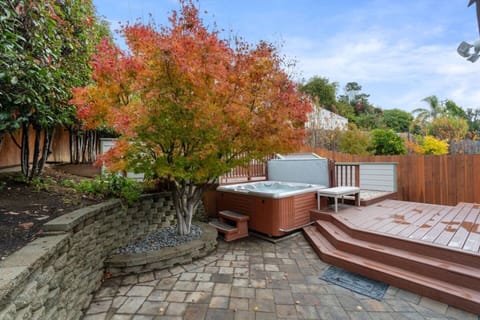 Unwind under the canopy of color—your private hot tub oasis awaits, nestled beneath vibrant foliage and surrounded by peaceful garden vibes