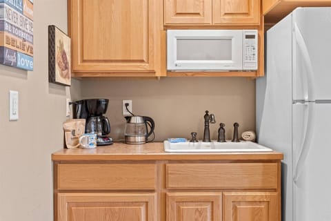 Kitchenette with microwave, sink, and full sized fridge
