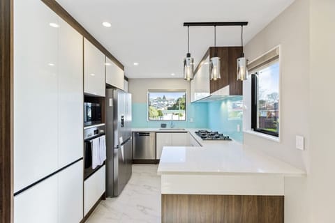 The kitchen is done in white with timber accents and has stainless steel appliances.