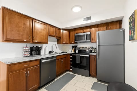 Spacious kitchen layout with full-size fridge and generous counter space for meal prep.