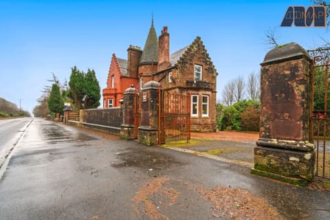A Grand Entrance: A view from the road showcasing the magnificent 1860 property, framed by the gateway entrance and large driveway, offering a warm welcome to your stay