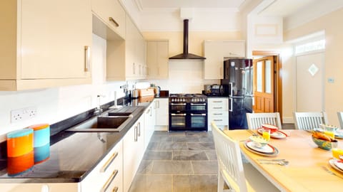 A bright and fully equipped modern kitchen with ample space for preparing meals and dining