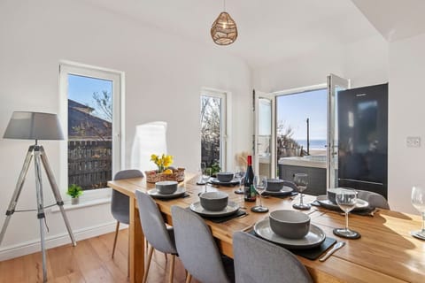 Swn y Don - Open-Plan Dining Area with Coastal Views The open-plan dining area features a spacious table for 10, with large windows offering stunning views of the coastline.