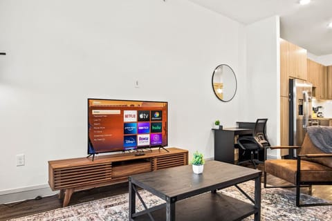 Bright and airy living room with plush seating, a large TV, and tasteful decor, creating the perfect space for relaxation and entertainment.