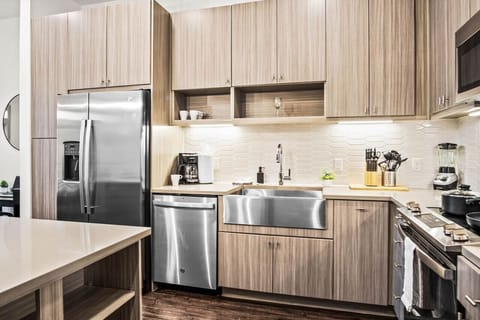 This contemporary kitchen is a chef's dream, featuring a large island, modern stainless steel appliances, and sleek cabinetry. The open layout ensures you can cook and entertain effortlessly, making it the perfect space for culinary creativity and social