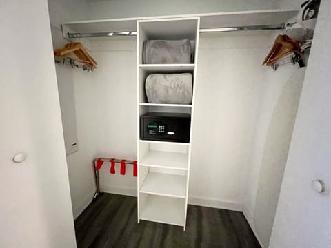 Spacious closet with safe, hangers, and storage shelves.