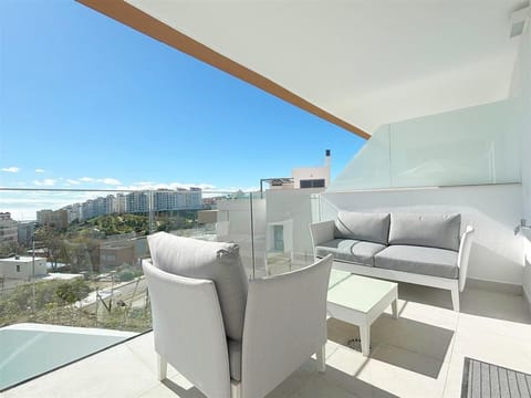 Sunny terrace facing south with outdoor seating for four guests and sea views