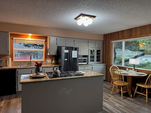 Open concert kitchen area.  Ocean view dining table next to it.
