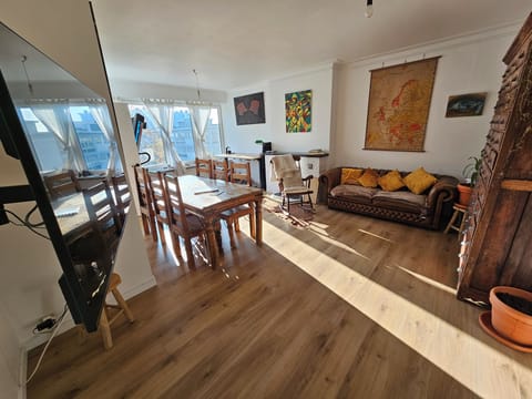 Bright cozy living room with sofa, dining table and Smart-TV incl streaming apps