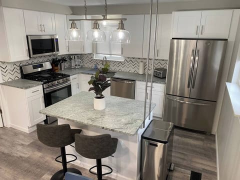 This kitchen is amenity-rich, with stainless steel appliances, a brand new pot or single-serving coffee maker, electric water kettle, 4-slice toaster, milk frother, and an air fryer.