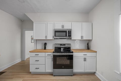 Kitchen: Modern design with sleek appliances and butcher block countertops awaits!