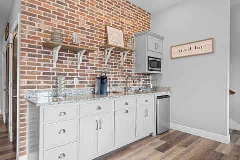 - Charming kitchenette featuring exposed brick, open shelving, and modern finishes for a cozy, rustic vibe
- Equipped with a Keurig, microwave, mini fridge, and essentials for your drink station
- Perfect for coffee breaks or midnight snacks