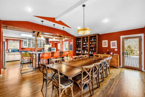 Elegant Dining Area with Deck Access - The spacious dining room features seating for 14, built-in shelving, and seamless access to the deck. The open layout connects to the kitchen and bar, making it perfect for gatherings and entertaining.